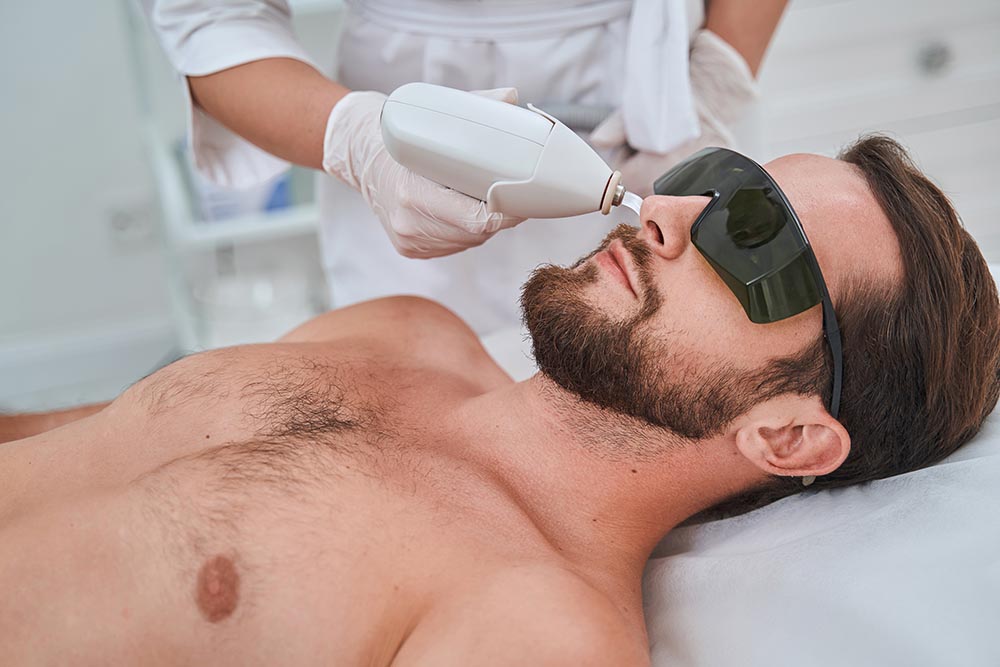A young man undergoing a laser hair removal procedure for nose hair