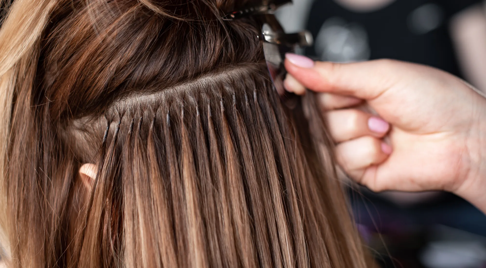 A stylist carefully managing extensions routine check-up.